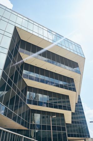 Modern glass building reflecting cloudy sky