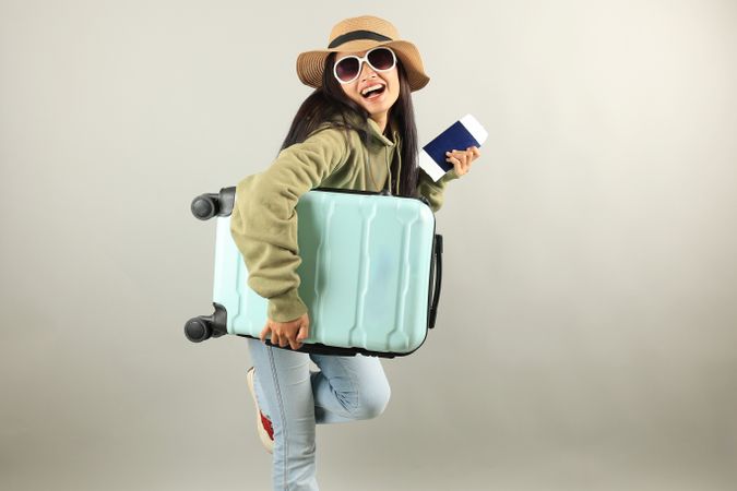 Traveler Asian Woman with Luggage, Ticket, and passport Isolated on Grey Background.
