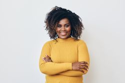 Happy Black woman standing with her arms crossed and smiling