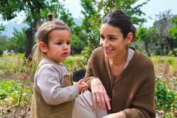Smiling mother and cute daughter spending time in verdant park