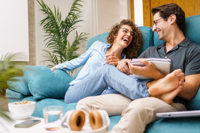 Cheerful couple with paper in living room