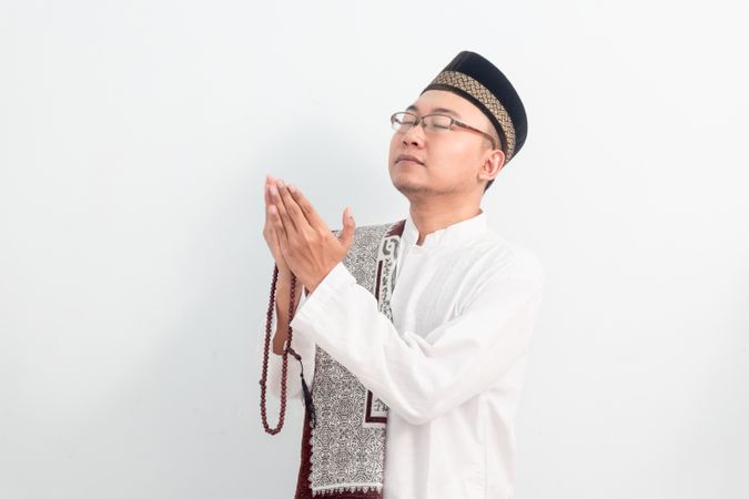 Asian Muslim man  doing praying hand pose during Ramadan