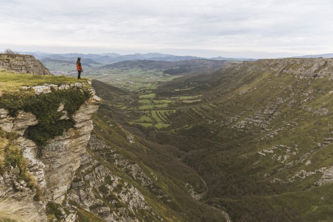 Man standing on cliff near valley