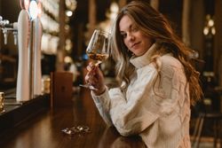 Stylish woman drinking wine in bar