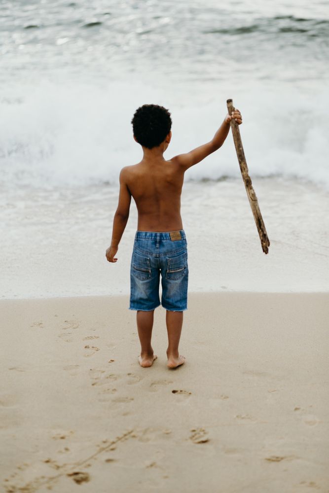 Black boy playing on beach