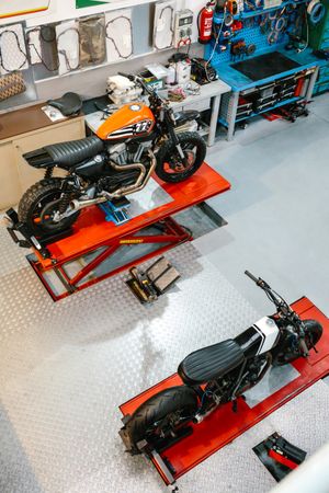 Top view of empty motorcycle workshop with custom motorbikes over platforms ready to review
