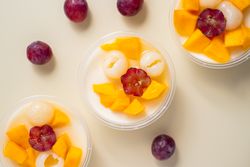 Three bowls of pudding fruit with a flower like shape from grape