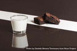Glass of milk and chocolate brownies on blocked background 5ayG85