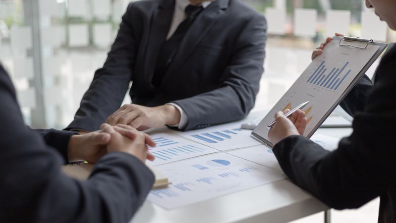 Business People Looking at Graphs in Meeting