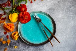 Rustic table setting with teal plate and fresh flowers