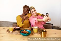 Two female friends taking selfie at breakfast together at home 0vxvB4