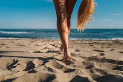 Woman legs on sandy beach