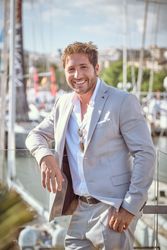 Cheerful businessman standing on balcony with glass wall