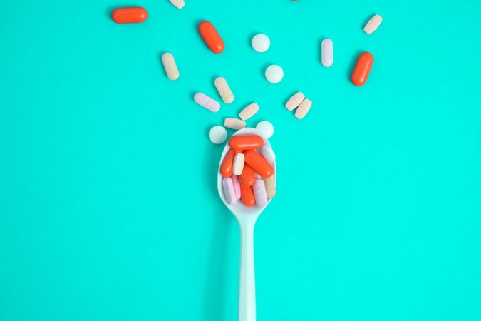 Spoon with a variety of colorful tablets with copy space