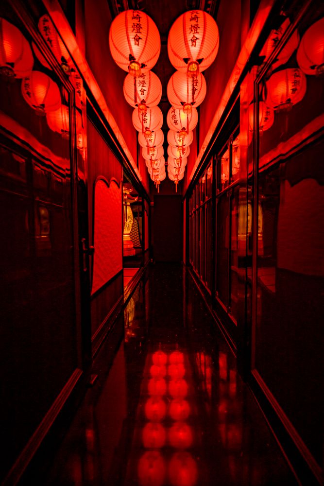 Lit red lanterns in a dark corridor