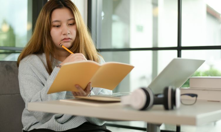 A woman student reading a note looks bored.