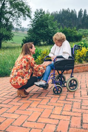 Young woman talking to mature woman in a wheelchair