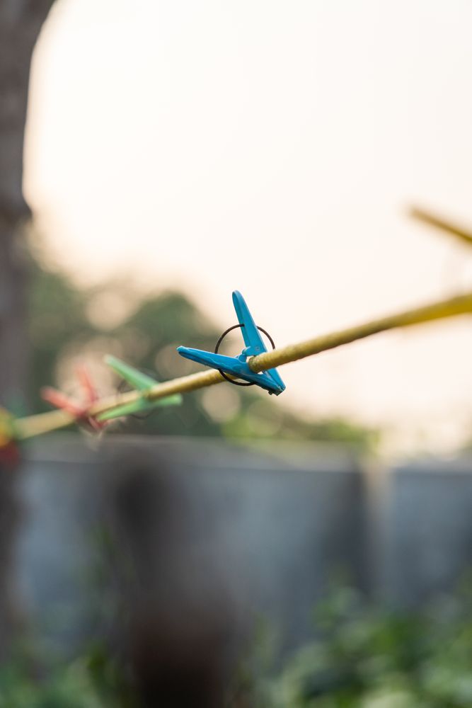 A single clothespin hanging on a clothesline