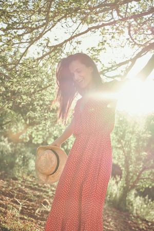Woman in dress with hat in park