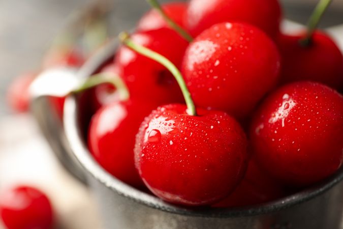 Metal mug with fresh red cherry, macro