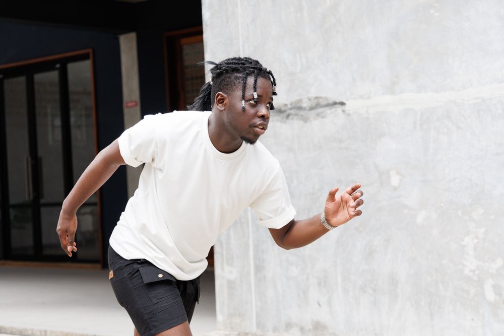 Black man in casual clothes standing running pose