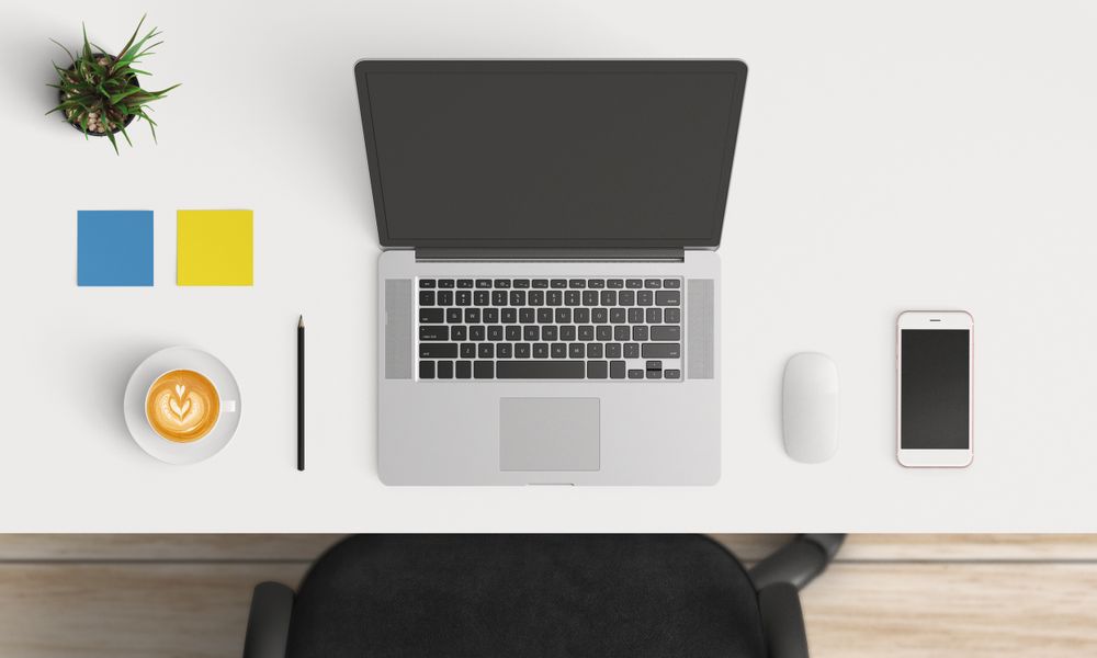 Modern workplace with laptop and smartphone copy space on table background. Top view. Flat lay style.