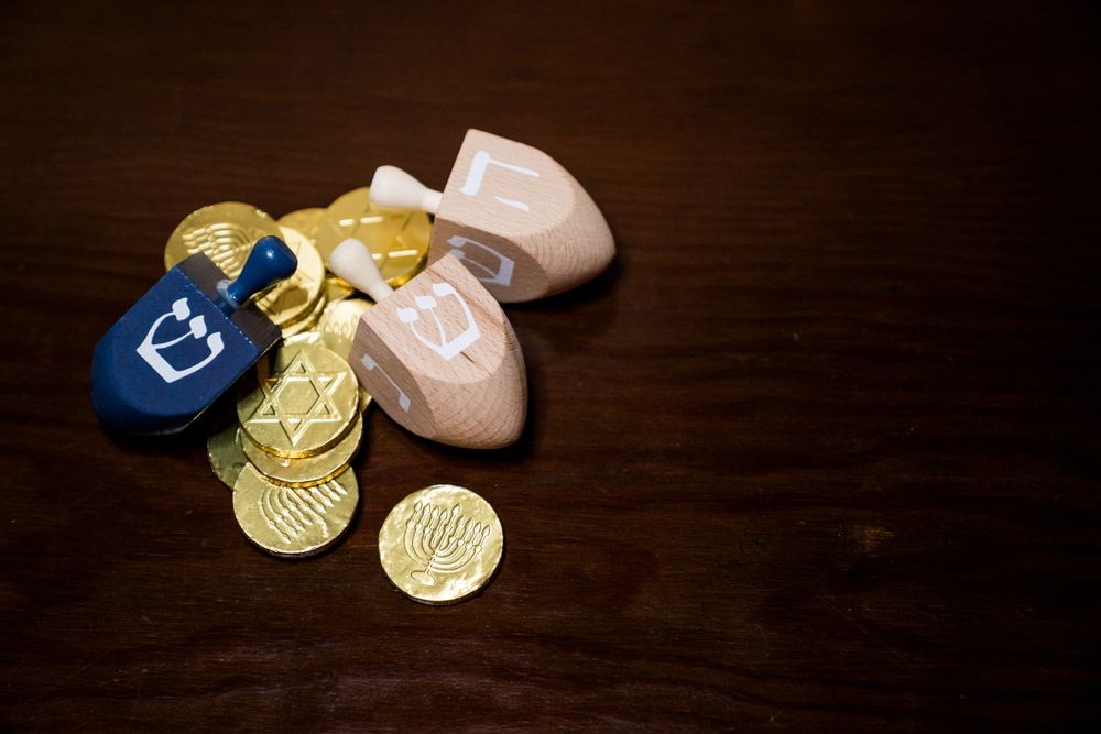 Top view of three dreidels with gelt for Hanukkah