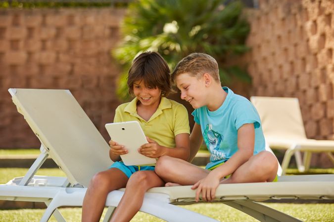 Boys using tablet in garden