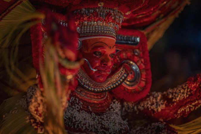 Indian man disguised as Theyyam as part of ritual form of dance worship