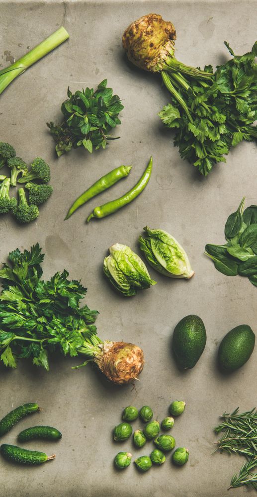 Arrangement of fresh green garden vegetables on concrete surface
