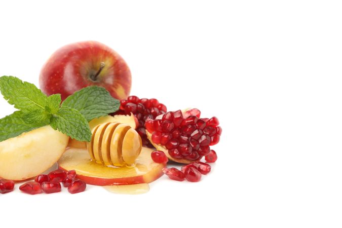 Honey dipper, pomegranate seeds, mint, and apple with copy space