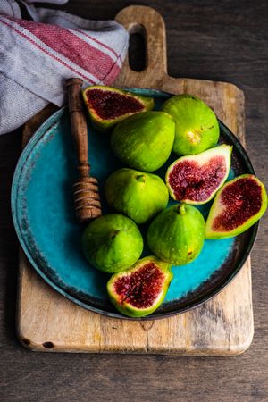Freshly picked figs on a plate with honey dipper