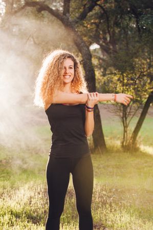 sportive woman stretching in sunlight