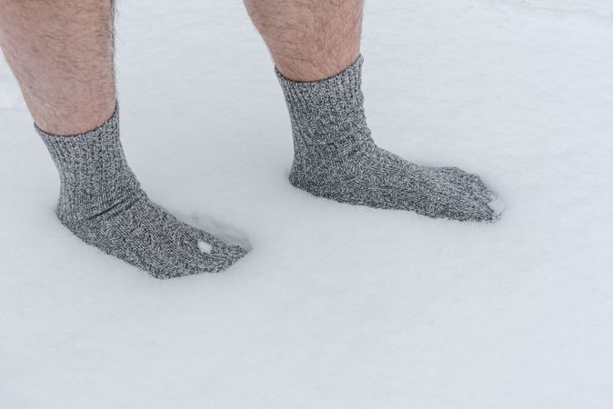 Close up of male feet in snow with socks