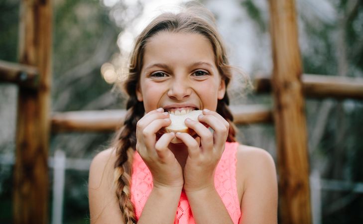 Portrait of a girl eating picnic food outdoors