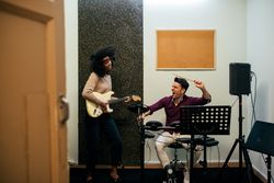 Man playing guitar and woman playing drums