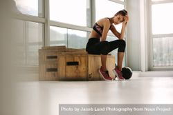 Exhausted fitness woman resting at gym 5r9zr1