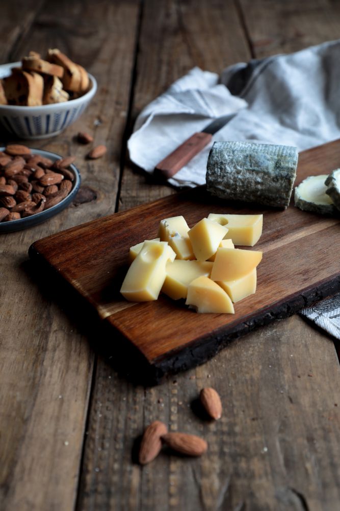 Croutons and nuts near board with cheese