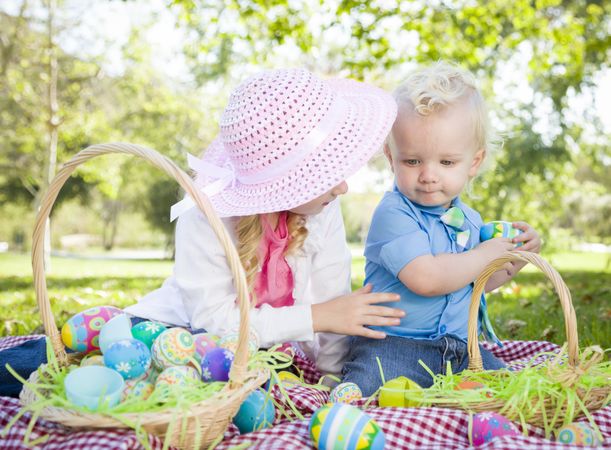 Cute Young Brother and Sister Enjoying Their Easter Eggs Outside