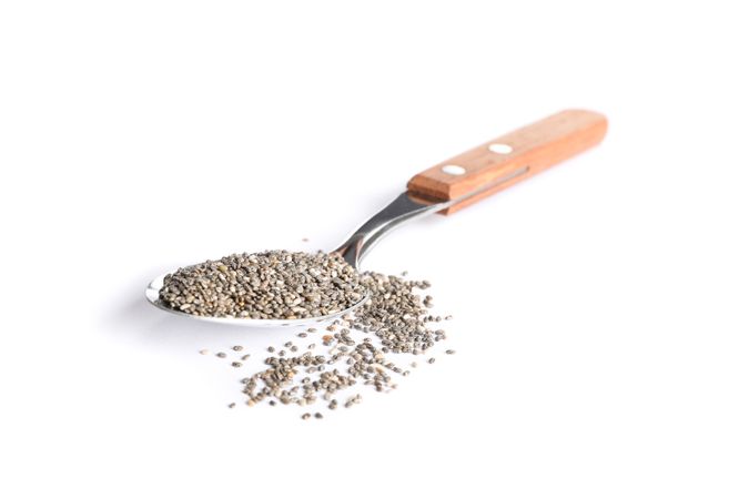 Chia seeds and spoon isolated on studio background