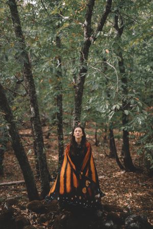 Woman in butterfly costume in forest