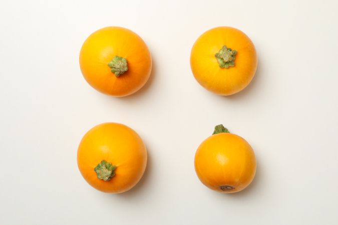 Four zucchini on blank background, top view
