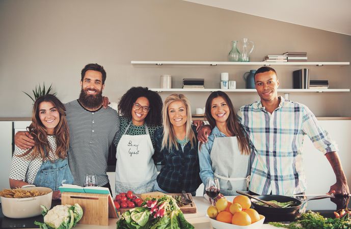 Friends standing behind food they’re about to cook in kitchen