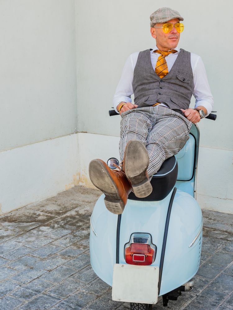 Trendy man lying on vintage scooter