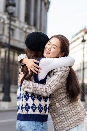 Asian female friends meeting and hugging