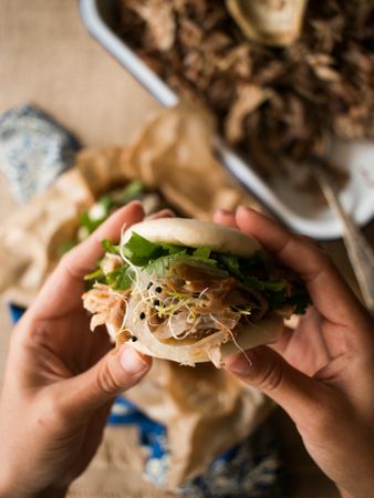 Crop hands with pulled pork bao buns