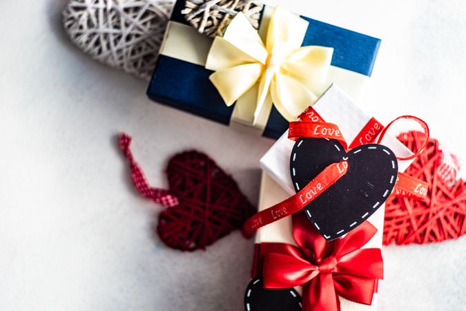 Multiple giftboxes wrapped in red ribbon with heart tag