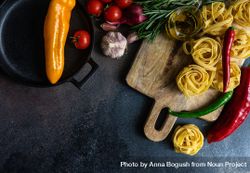 Top view of homemade Fettuccine pasta and ingredients on stone rustic background with copy space 5wXgVA