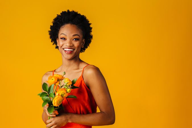 Happy Black woman holding a ranunculus bouquet