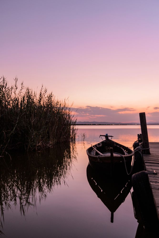 Moored boat by wooden pier